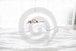 Asian woman Beautiful young smiling woman sitting on bed and stretching in the morning at bedroom after waking up in her bed full