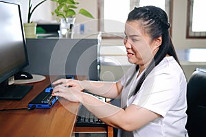 Asian woman with blindness disability using computer with refreshable braille display or braille terminal a technology assistive