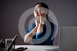 Asian woman in blue shirt working on a laptop was sick with irritate itching her skin sitting at office.  on white photo