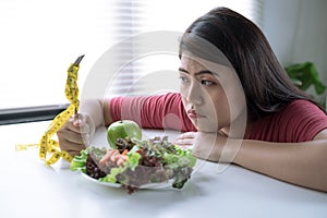 Asian woman is bored when she has to eat vegetables, She wants to eat delicious food, She is losing weight, Healthy eating ideas