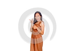 An Asian woman in brown tank top points her finger to the empty space