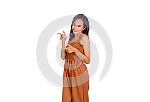 An Asian woman in brown tank top points her finger to the empty space