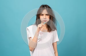 Asian woman brushing teeth and towel on the shoulder on blue background, Concept oral hygiene and health care