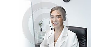 Asian woman Call center agent with headset working on support hotline in modern office with copy space