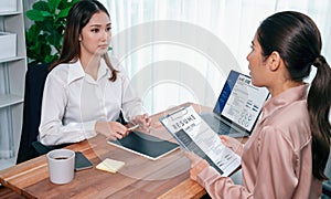 Asian woman candidate hands over her resume to the interviewer. Enthusiastic