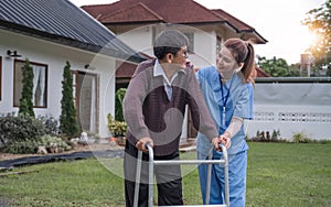 Asian woman caregiver helping senior man walking. Nurse assisting he old man patient at nursing home. Senior man using