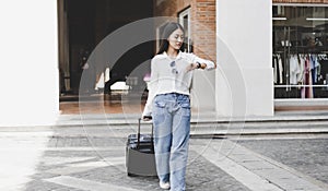 Asian woman carried a suitcase and hurried to her accommodation before her friend`s appointment, Trolley bag, Long weekend travel