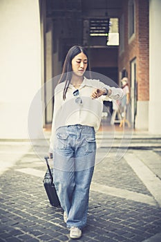 Asian woman carried a suitcase and hurried to her accommodation before her friend`s appointment, Trolley bag, Long weekend travel