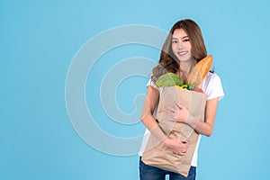 Asian woman carry paper shopping bag from supermarket with vegetables inside a bag