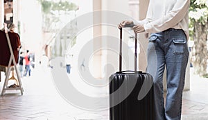 Asian woman carrying a big black bag to travel during the vacation of the year