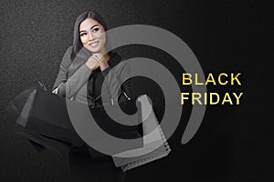 Asian woman carrying a shopping bag with Black Friday text with a colored background
