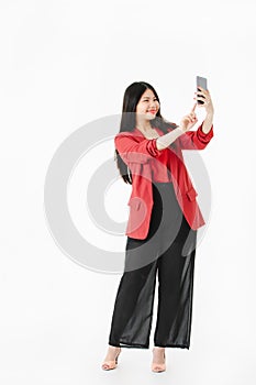 Asian woman in casual dress holding smartphone selfie