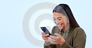 Asian woman, cellphone and excited with happiness, laughing and on studio blue background. Social media, streaming or