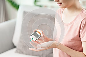 Asian woman checking blood sugar level by Digital Glucose meter, Healthcare and Medical, diabetes, glycemia concept