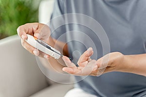 Asian woman checking blood sugar level by Digital Glucose meter, Healthcare and Medical, diabetes, glycemia concept