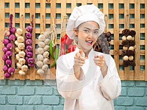 Asian woman in chef`s uniform is cooking in the kitchen. portrait female cook smiling with copy space.