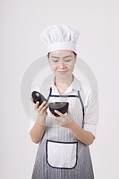 An asian woman in chef uniform holding a rice bowl