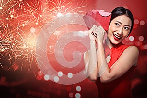 Asian woman in cheongsam dress holding angpao