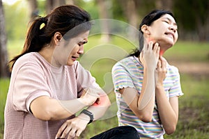 Asian woman and child girl itching her arm and neck from insect bites,mosquito bite,risk of dengue fever,malaria,itching of skin