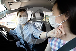 Asian woman,child girl in protective face masks with fastening seat belt in car,mother help care her daughter wear medical mask