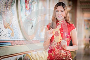Asian woman in chinese dress holding couplet 'Happy' (Chinese w