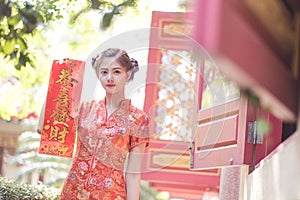 The Asian woman in chinese dress holding couplet 'Lucrative' (C