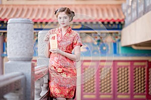 The Asian woman in chinese dress holding couplet 'Lucrative' (C