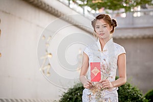 The Asian woman in chinese dress holding couplet 'Lucrative' (C