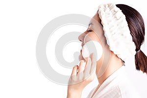 Asian woman cleaning beautiful face by wiping, using cotton pads, cleansing lotion, facial toner. Attractive beautiful young girl