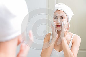 Asian woman cleaning face skin enjoy herself with bubble cleansing foam. photo