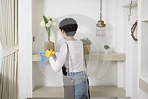 Asian woman with cleaning gloves using alcohol spray sanitiser to cleaning house, healthy lifestyle concept