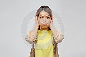 Asian woman closing ears by hands