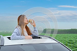 Asian woman with coffee and standing out of car sunroof. Relaxing and freedom with spring time. Young tourist travel alone in