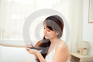 Asian woman combing her hair with anxiety