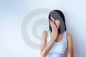 Asian woman covering her mouth and smell her breath with hand upter wake up on white blackground,Bad smell