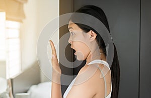 Asian woman covering her mouth and smell her breath with hands upter wake up,Bad smell