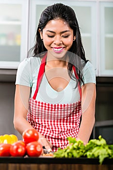 Asian woman cutting vegetables and salad