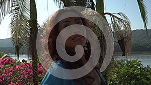 Asian woman dancing happily and enjoying a sunny day on the own terrace at morning.