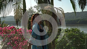 Asian woman dancing happily and enjoying a sunny day on the own terrace at morning