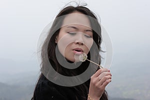 Asian woman and dandelion