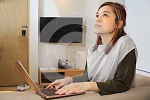 Asian woman deep thought when using laptop