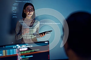 asian woman developers collaborating on a coding project, with one member presentation at code projected on the wall while the
