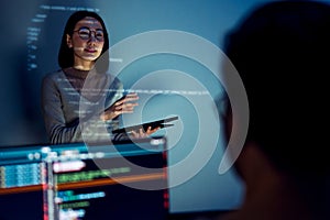 asian woman developers collaborating on a coding project, with one member presentation at code projected on the wall while the