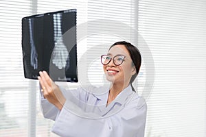 Asian woman doctor in hospital looking at x-ray film healthcare