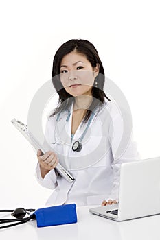 Asian woman Doctor or Nurse working at a desk holding a medical pad