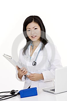 Asian woman Doctor or Nurse working at a desk holding a medical pad