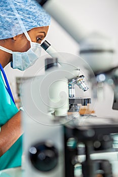 Asian Woman Doctor or Scientist Using a Microscope In Laboratory