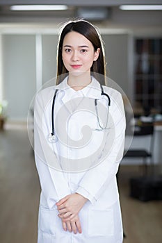 Asian woman doctor stands confidently and smiles