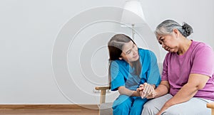 Asian woman doctor take care and encourage elderly patient, which she is saddened from depression