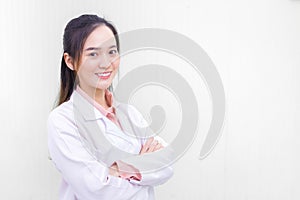 Asian woman doctor who she has a black long hair, wear a stethoscope and a white lab coat as a uniform while arm cross at office